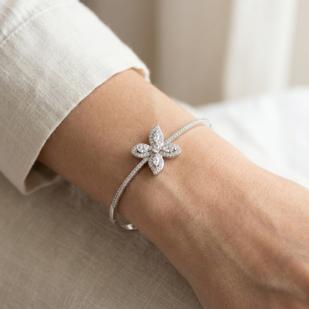 Silver Butterfly Kada worn on a woman's wrist, highlighting the intricate pavé stone setting and sleek band.