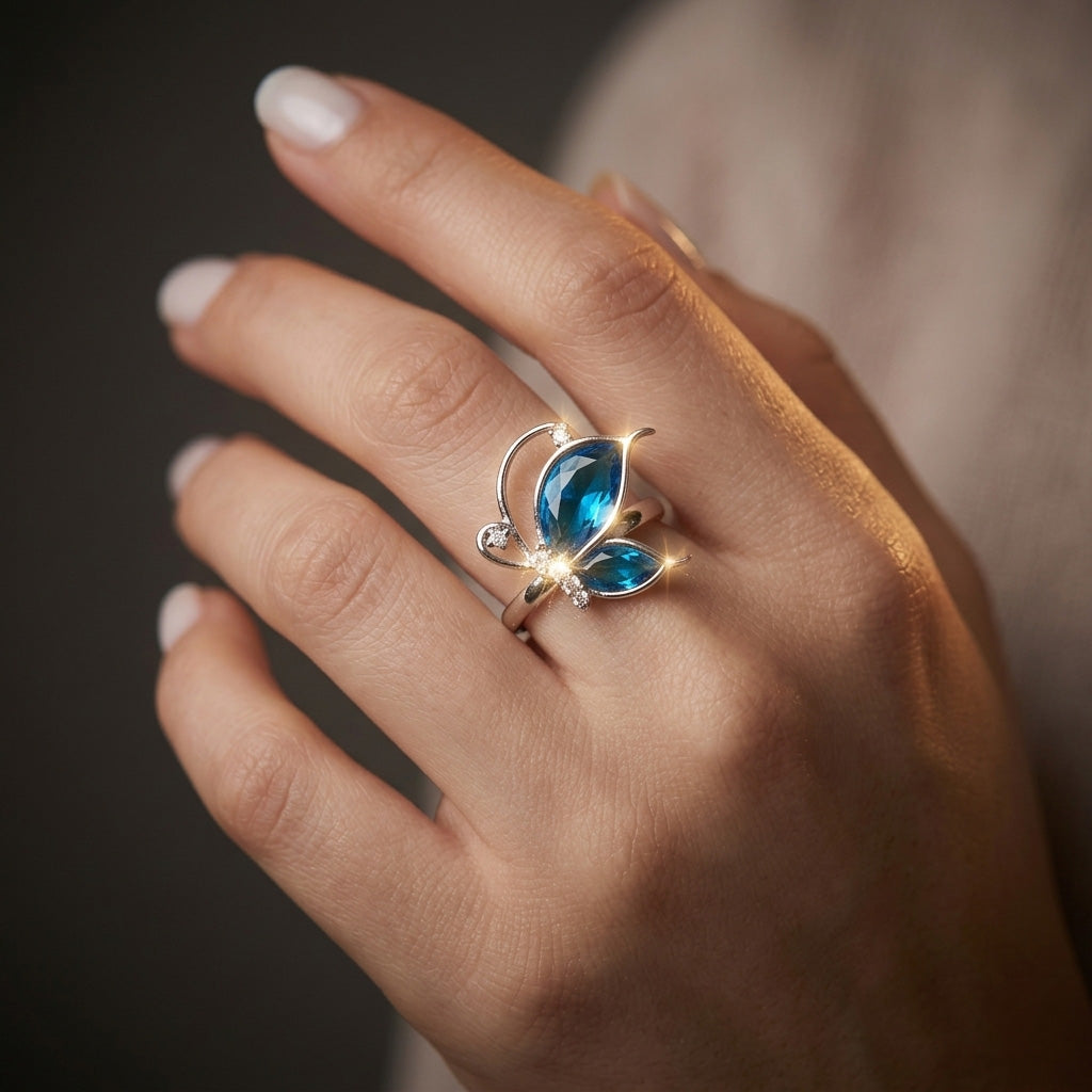 Sparkling blue butterfly silver ring worn on a hand