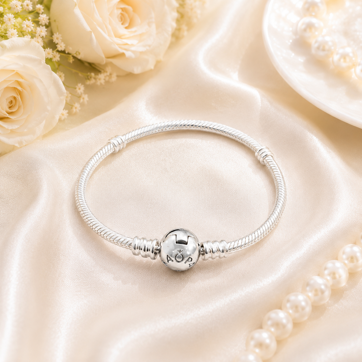 Classic silver snake chain charm bracelet with a round snap clasp displayed on a clean white background