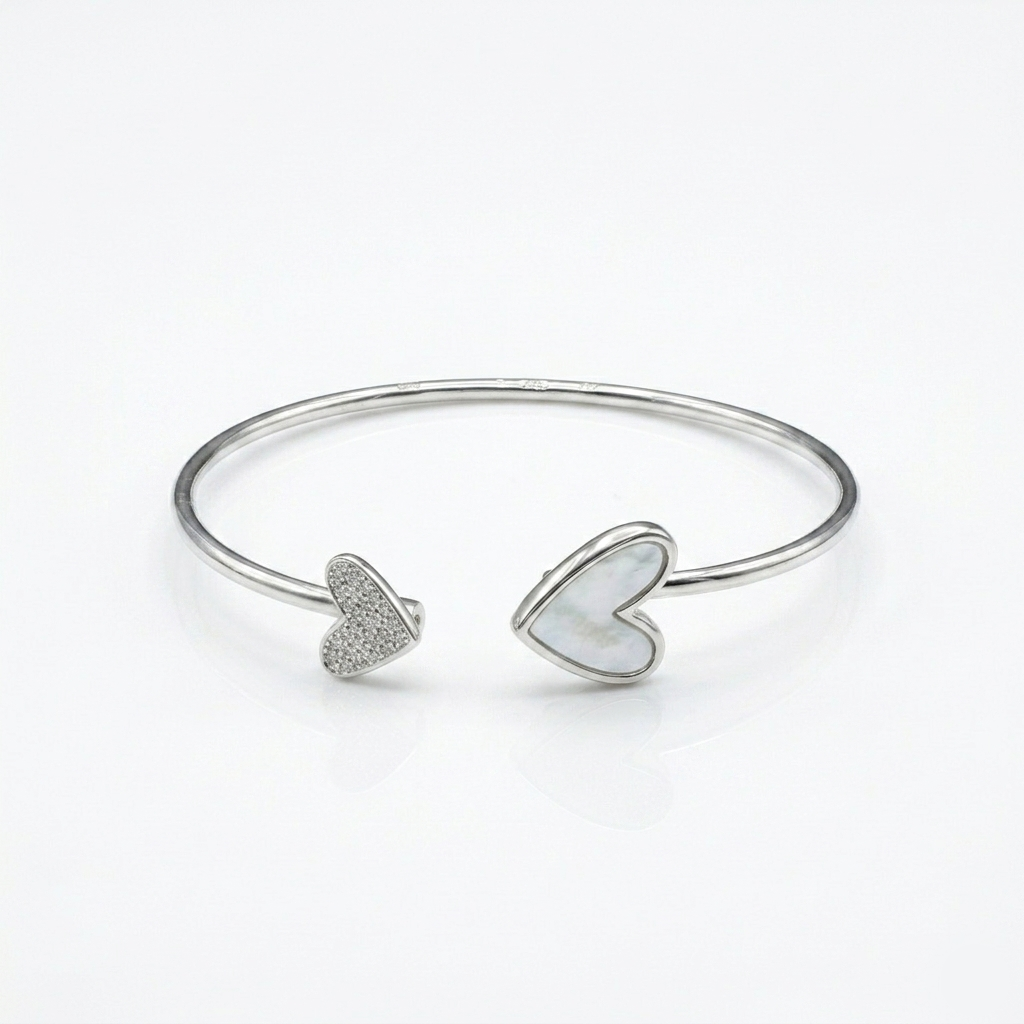 Studio shot of a Double Heart Open Silver Bracelet against a seamless white background highlighting the shiny mother-of-pearl and pavé settings