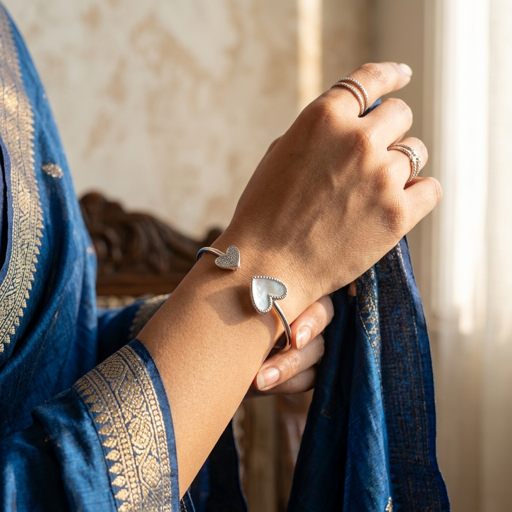 Woman wearing a blue ethnic outfit adorned with a Double Heart Open Silver Bracelet featuring two asymmetrical heart motifs 