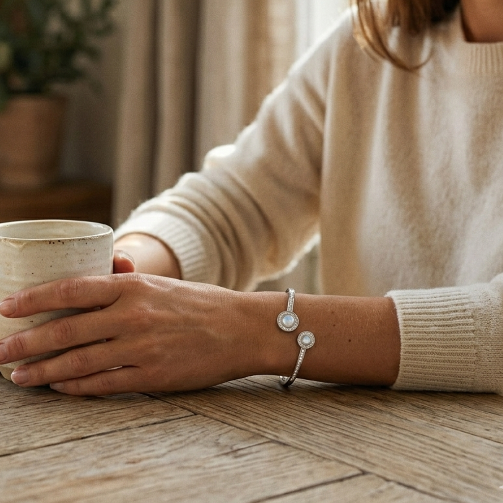 Lifestyle image of a woman in a beige sweater holding a ceramic mug, showcasing the Dual Circle Silver Open Kada on her wrist.
