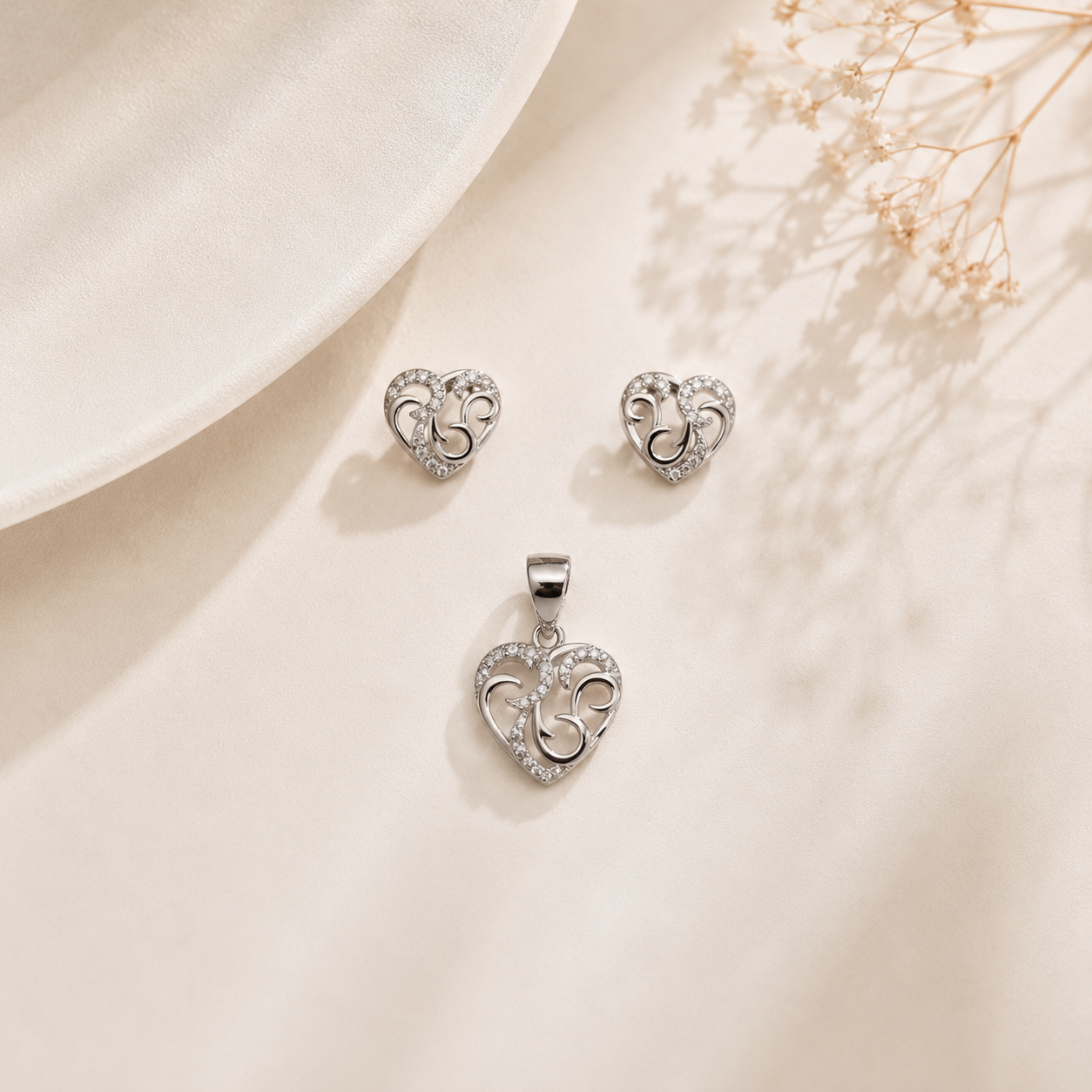 Close-up of elegant silver heart jewelry set featuring intricate openwork