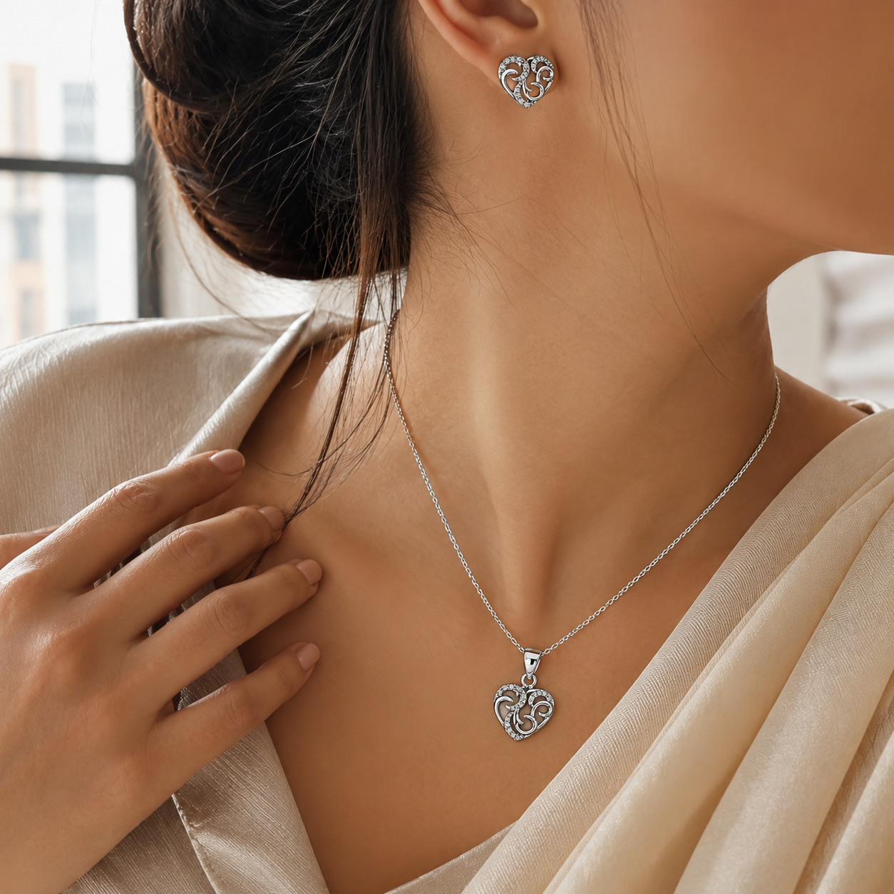 Matching silver tone heart stud earrings and pendant with clear stones