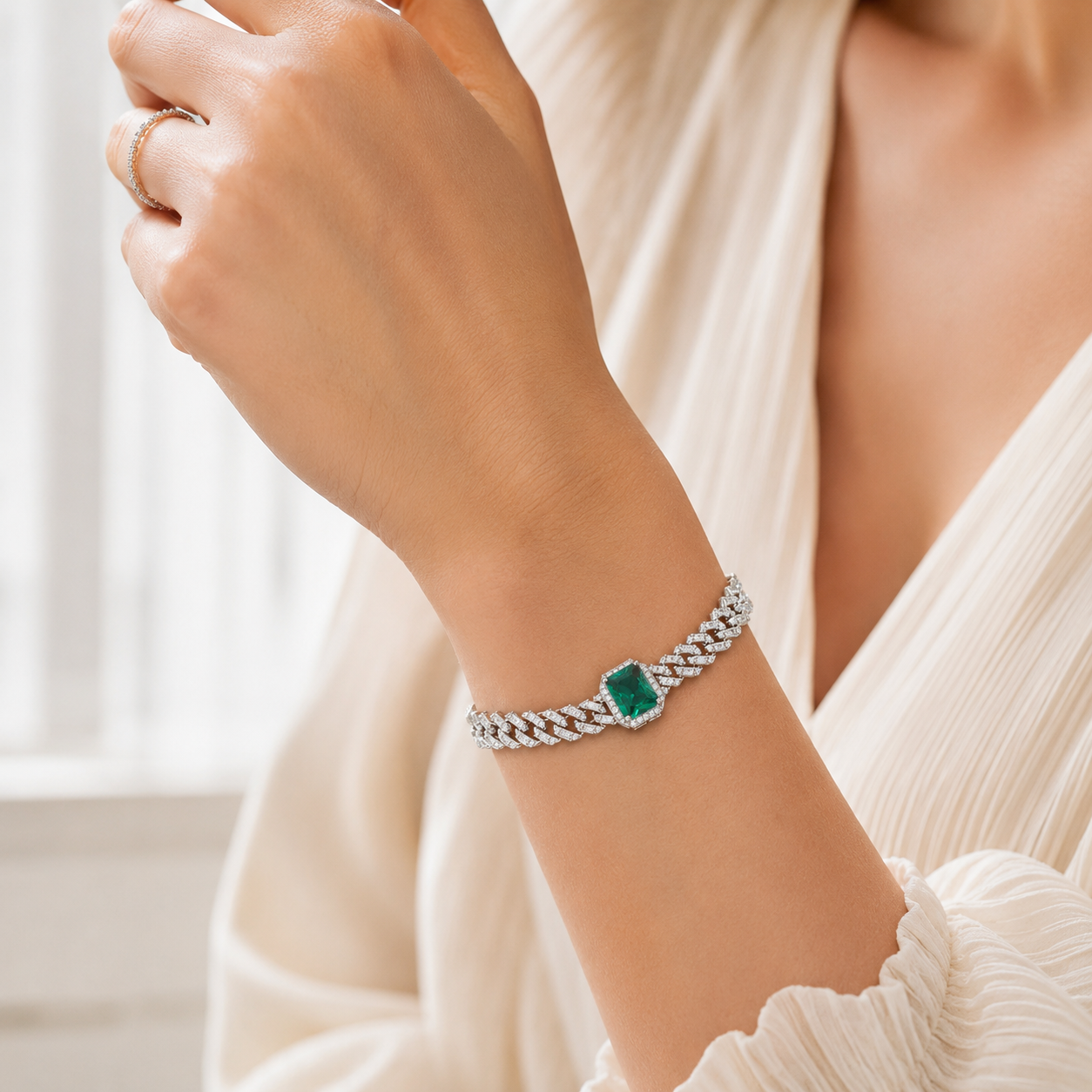 Top-down view of a silver-tone chain bracelet highlighting the vibrant green rectangular crystal