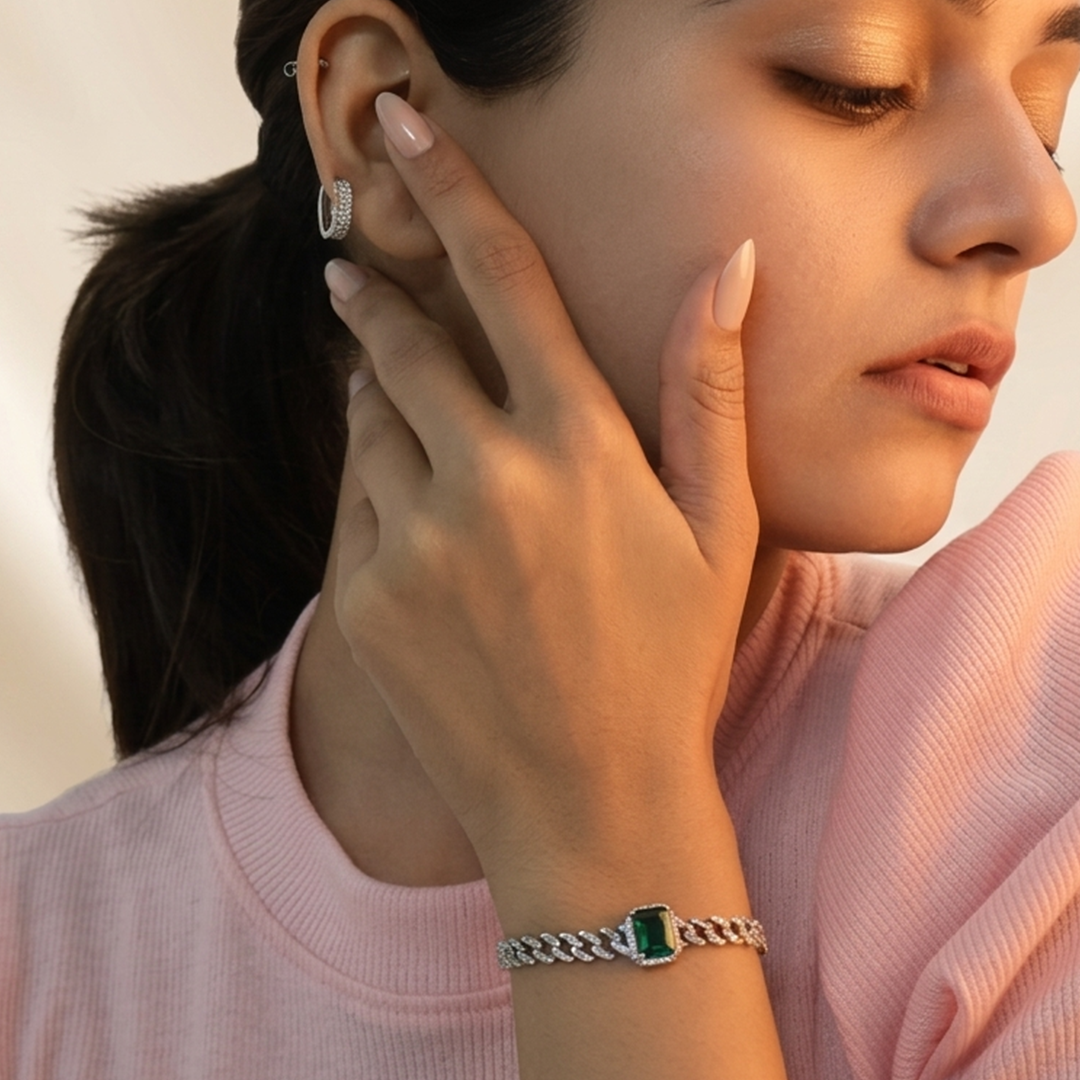 Close-up of the micro-pave halo surrounding the emerald-cut green gemstone on a silver bracelet