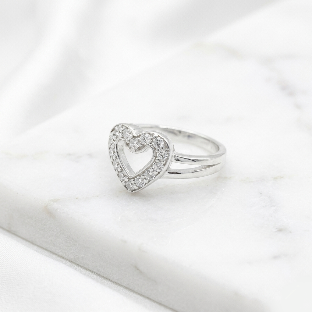 Heart Shape Silver Ring a stone-studded open heart design resting on white marble.