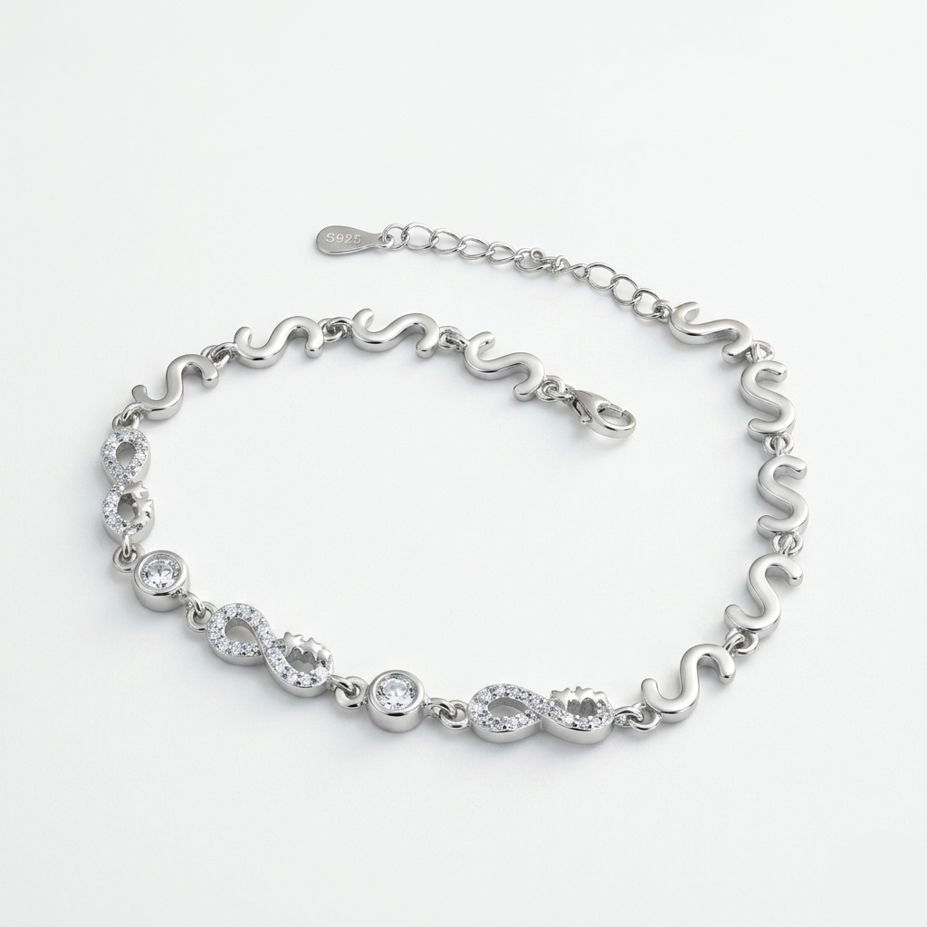 Silver-toned bracelet featuring alternating smooth infinity curves and crystal-studded circular links.