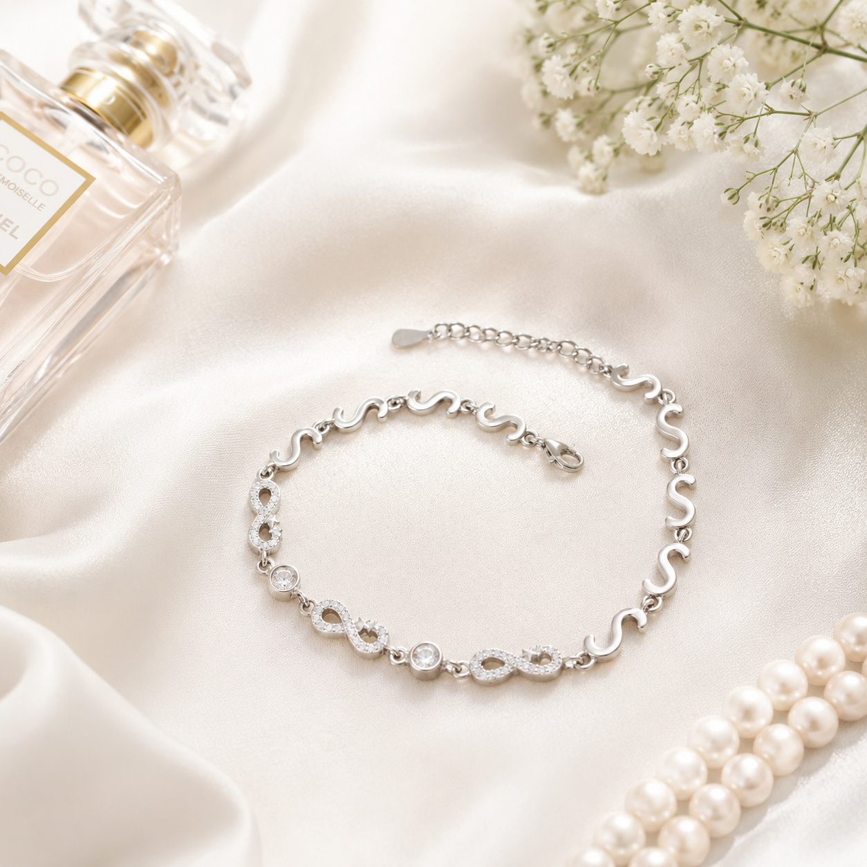 Elegant silver link bracelet lying flat on a white surface highlighting the continuous S-curve design.