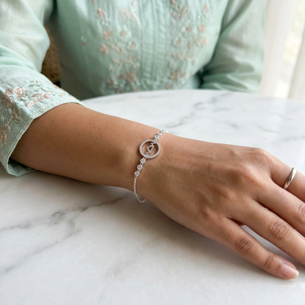 A woman wearing a delicate silver bracelet with a sparkling "MOM" center charm on her wrist.