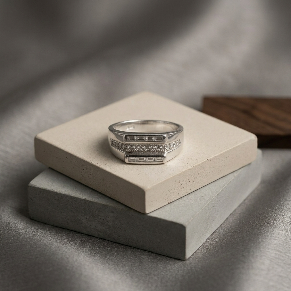 Luxury Silver Ring displayed on layered concrete blocks against a smooth grey silk backdrop