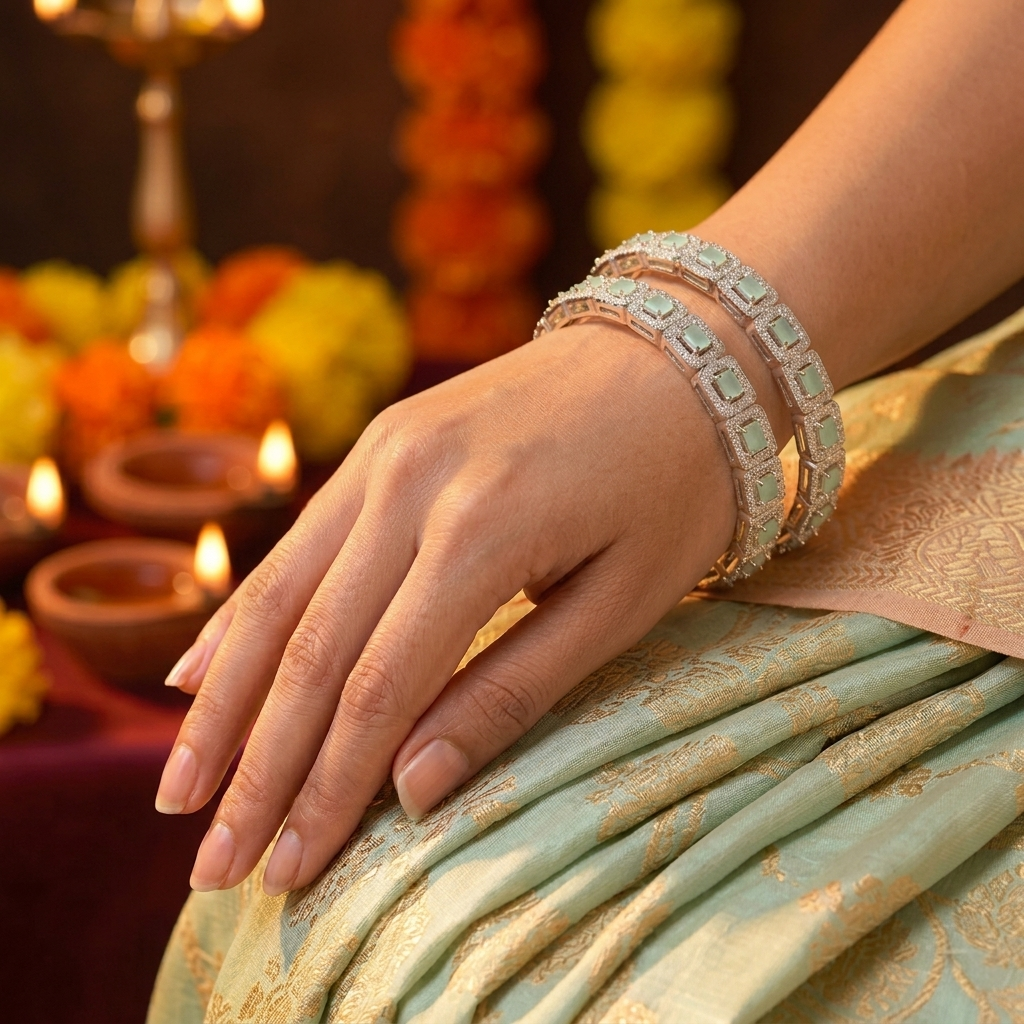 Woman's hand wearing Mint Green Stone Silver Bangles against a festive background with lit diyas and marigold flowers.