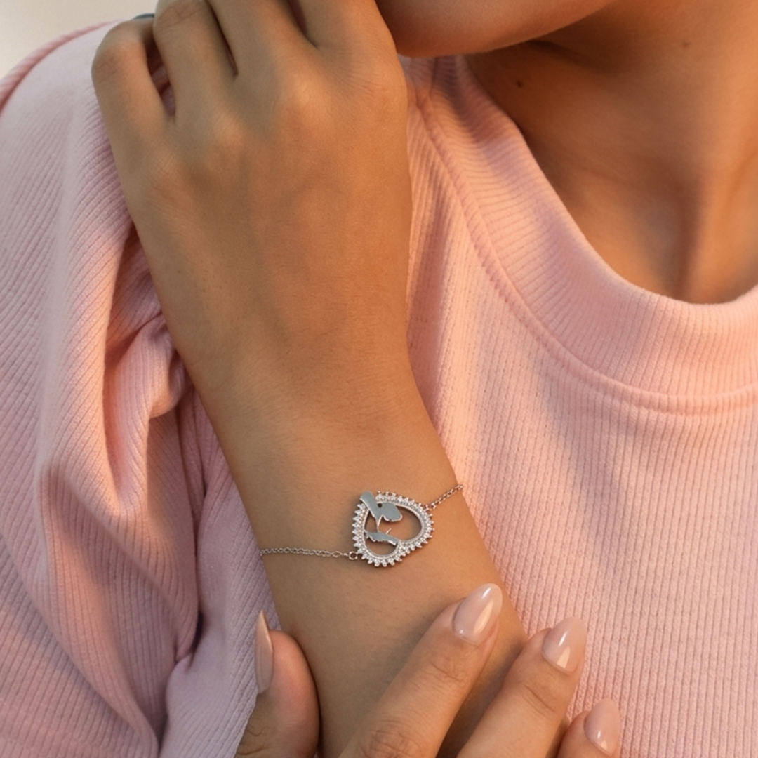 Detail of the intricate cutout design inside the heart pendant of the silver bracelet