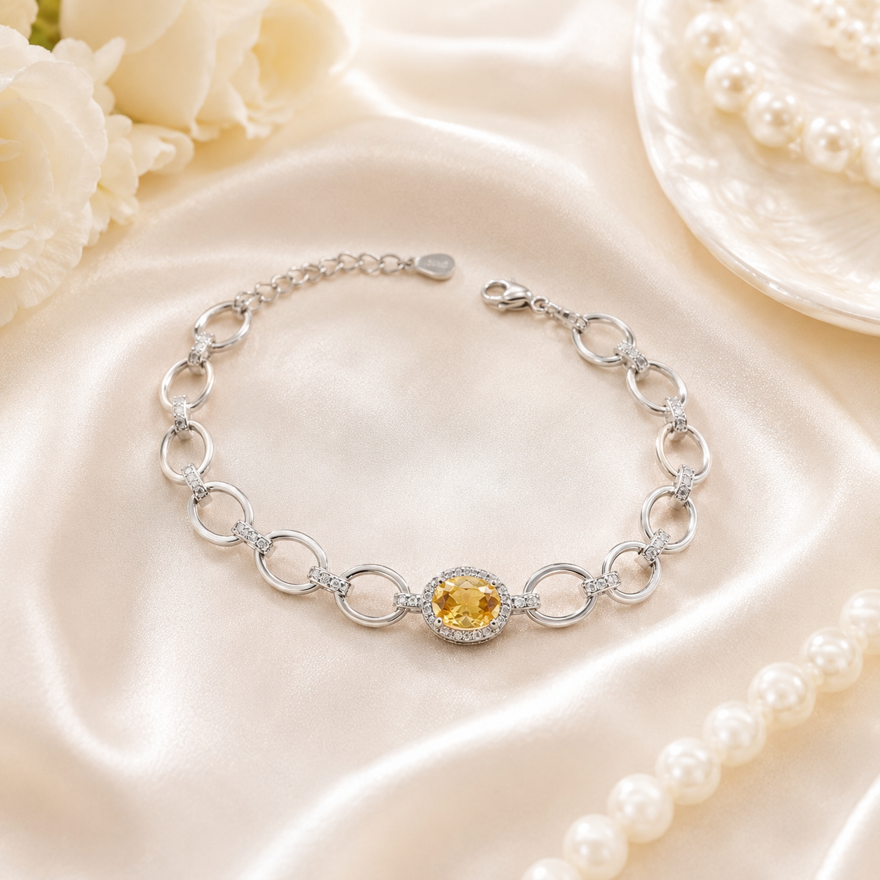 Close-up of the interlocking silver links and lobster clasp on the yellow halo bracelet