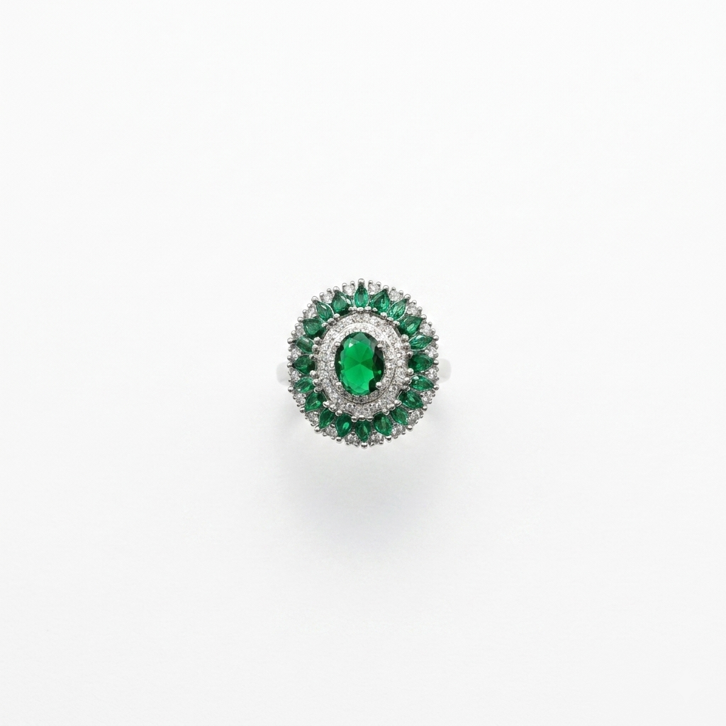 Top-down view of a Party Wear Green Stone Silver Ring with a large oval green center stone surrounded by white and green crystal halos on a white background.