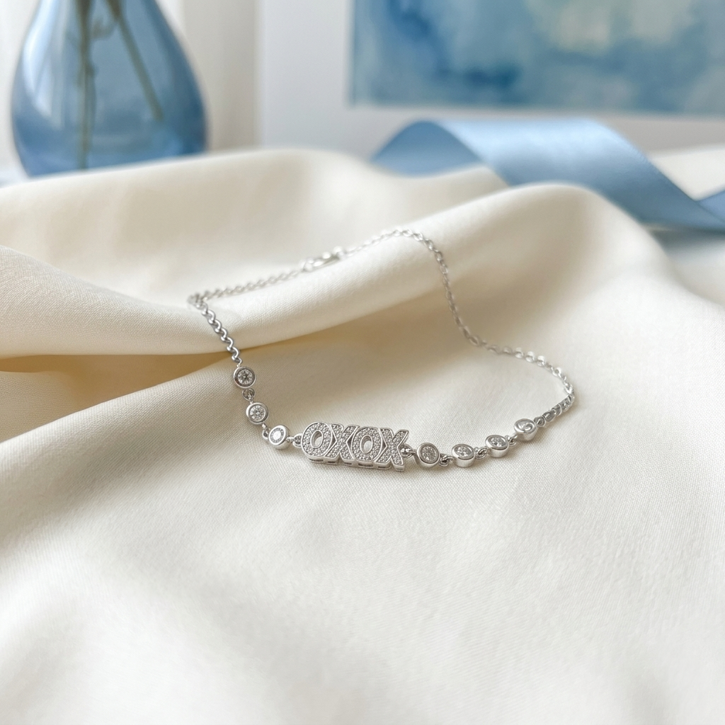 Close-up of the Raksha Sutra Owl Silver Bracelet resting gently on draped white and blue satin fabric. 