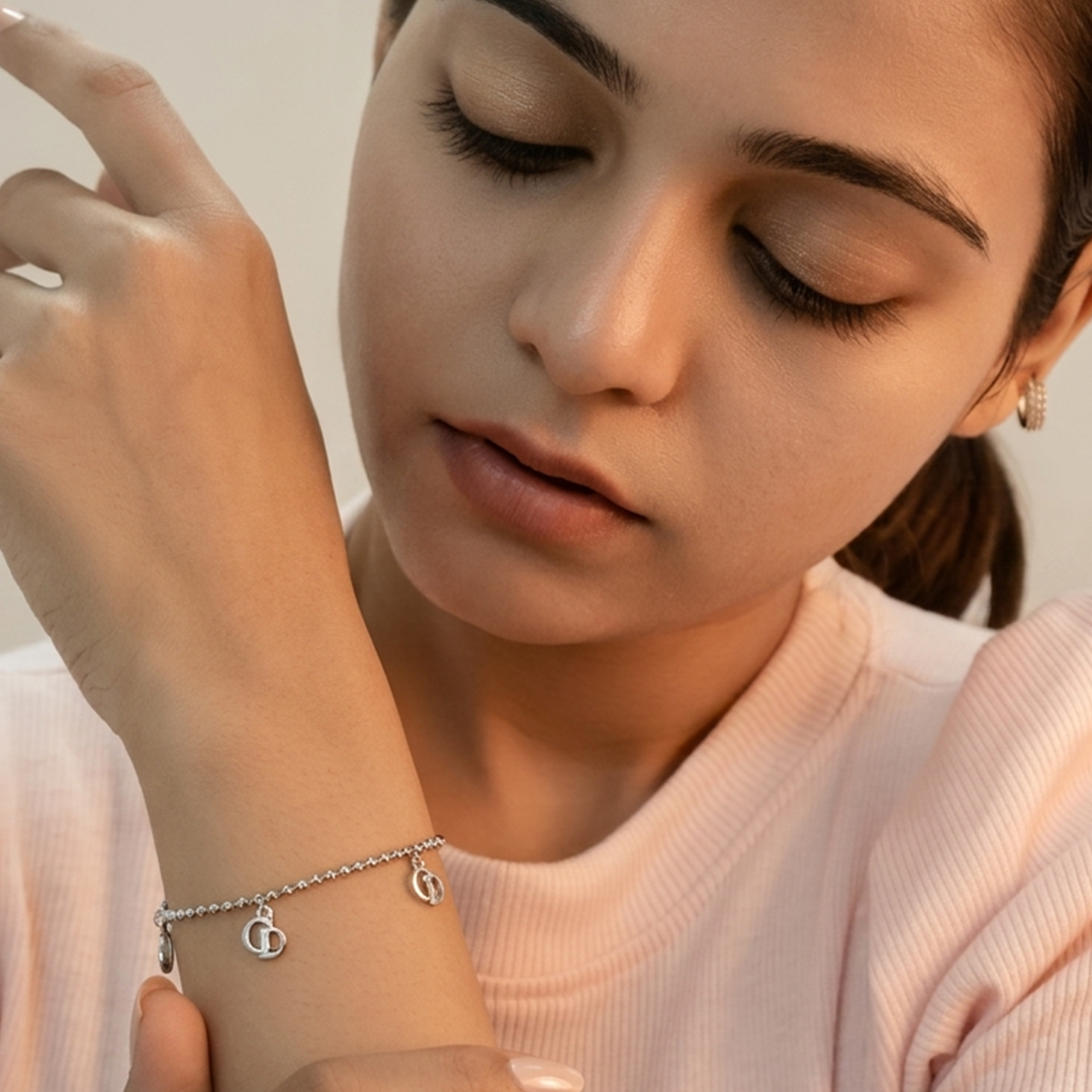 Full view of the silver charm bracelet with interlocking circular dangling motifs on a white background