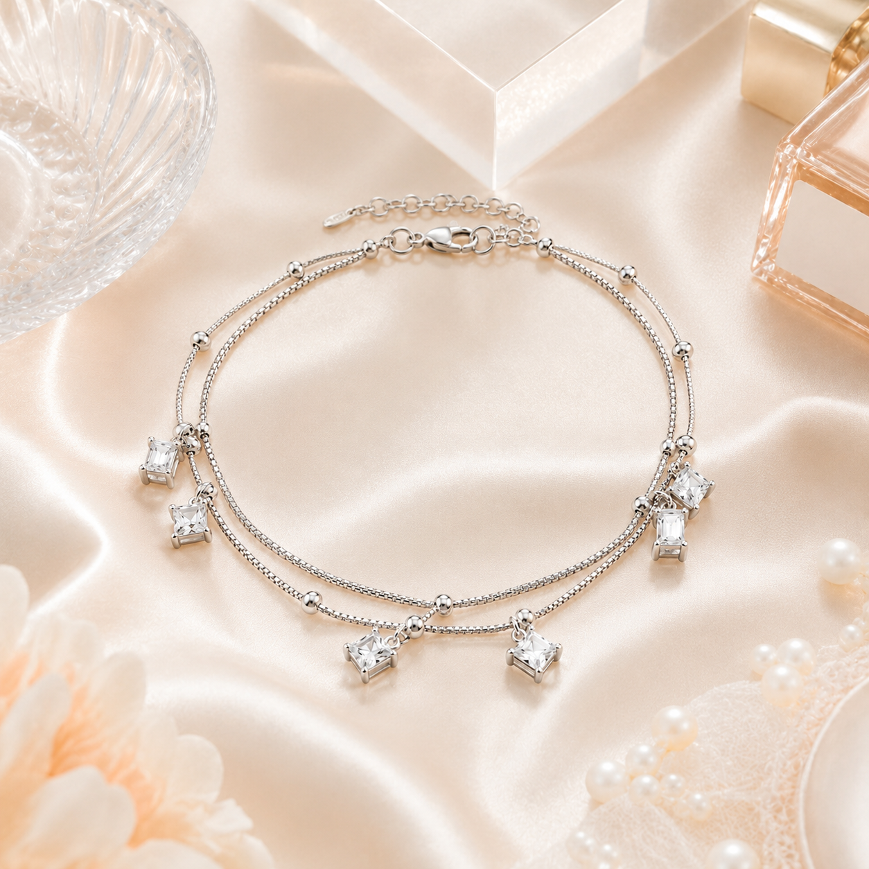 Detailed view of the square-cut clear stones hanging from the dual-layer silver anklet