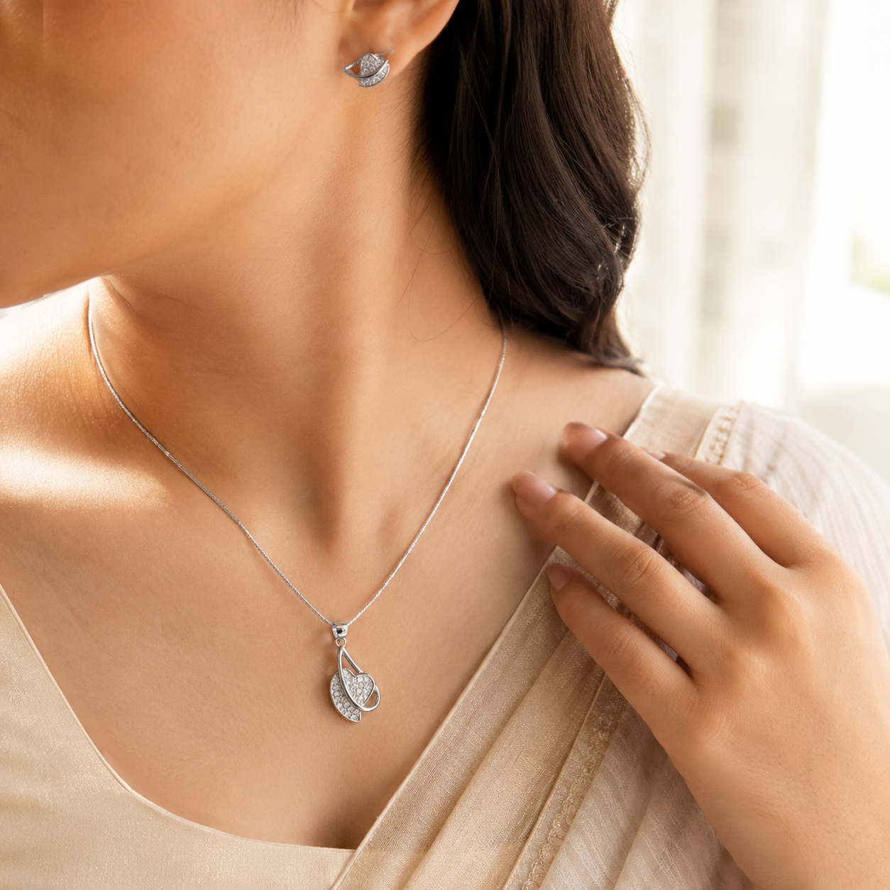 Close-up of diamond-studded leaf motif pendant with matching push-back stud earrings