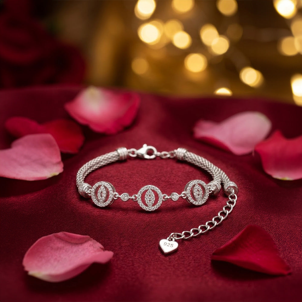 Silver Flower Charm Bracelet on red velvet surrounded by rose petals