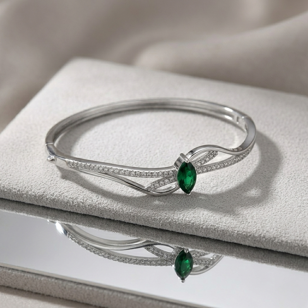 Silver Green Stone Kada for Women with a green center stone resting on a textured grey surface with a mirror reflection