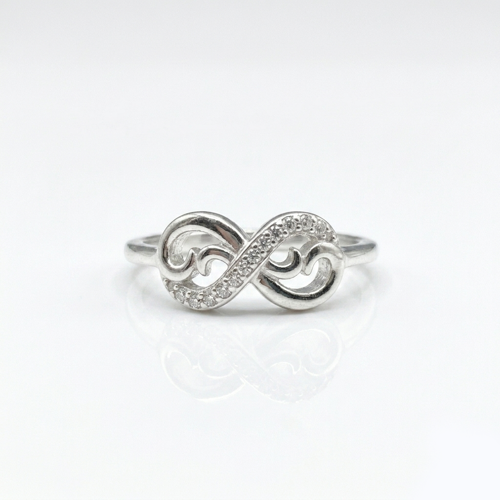 Close-up macro shot of the Silver Half-Pave Infinity Ring showing the sparkling pavé stones and polished inner swirls on a pure white background