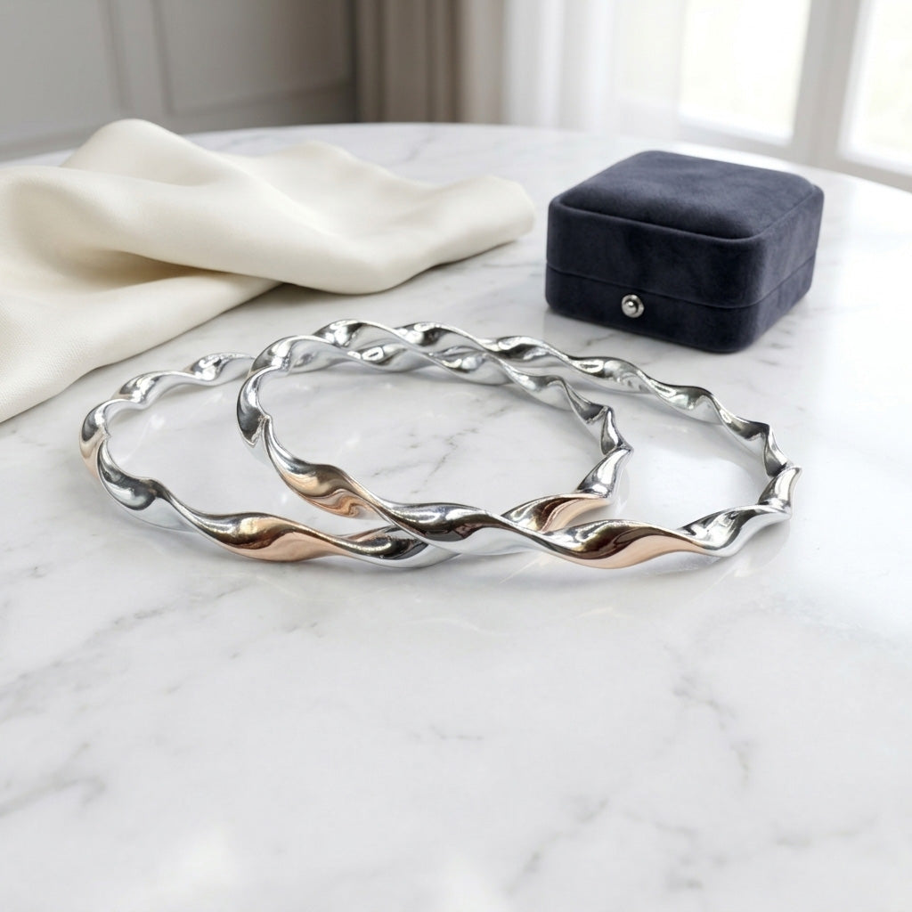 The Silver Twisted Bangle Set for Women displayed flat on a white marble surface
