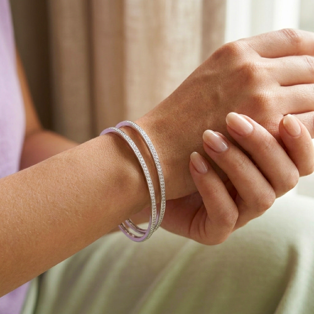 Close-up of a woman's wrist elegantly modeling the Slim Stone Silver Bangle Pair