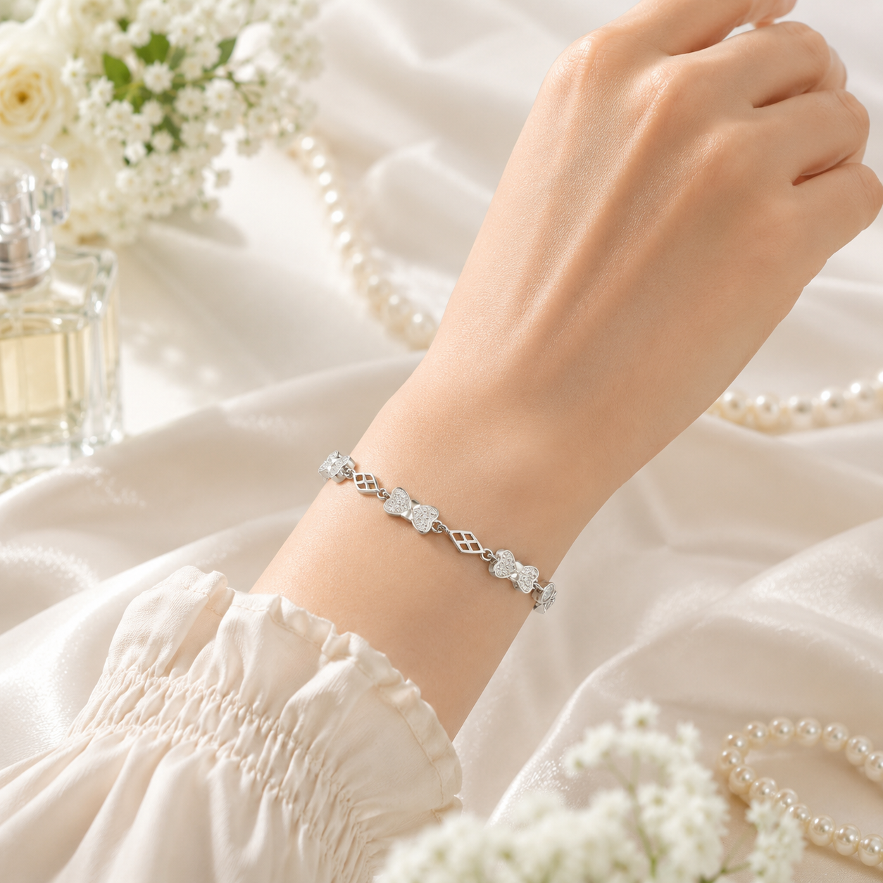 Close-up of geometric and bow-shaped links on a sterling silver bracelet.