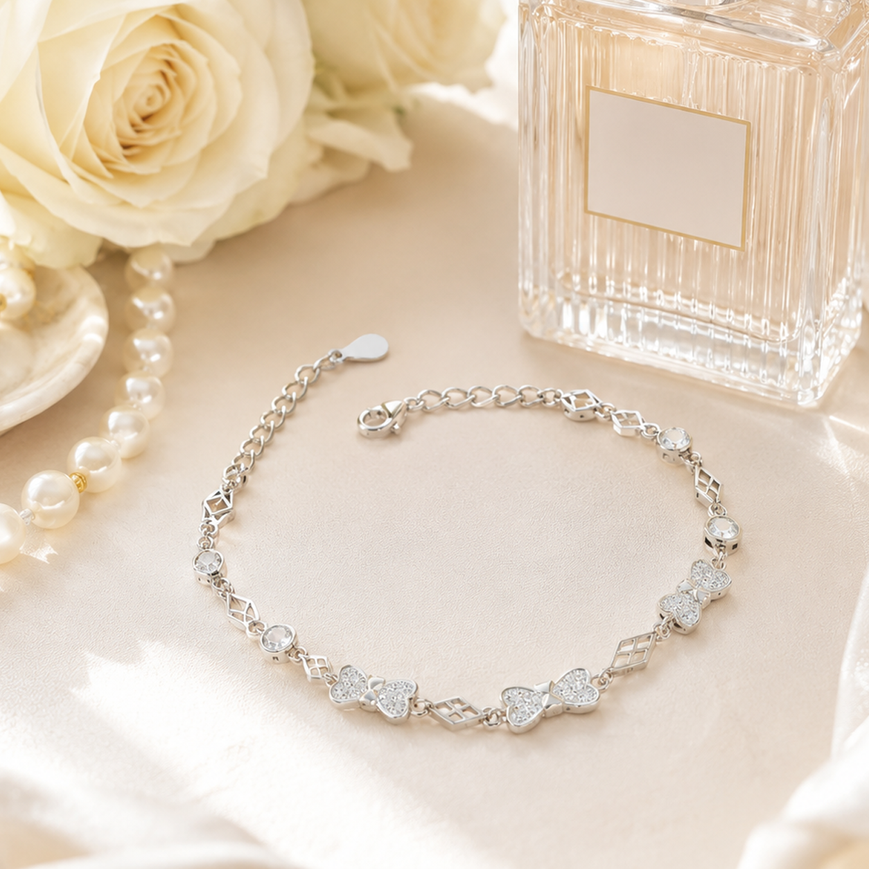 Adjustable silver chain bracelet with shimmering bow and diamond-shaped cutouts.