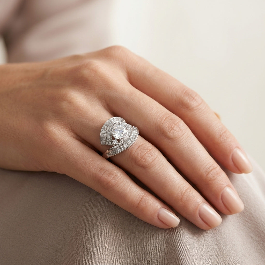 Close-up of a woman's hand wearing the Swirl Diamond Silver Ring, showcasing its sparkling round center stone and swirling silver bypass design.