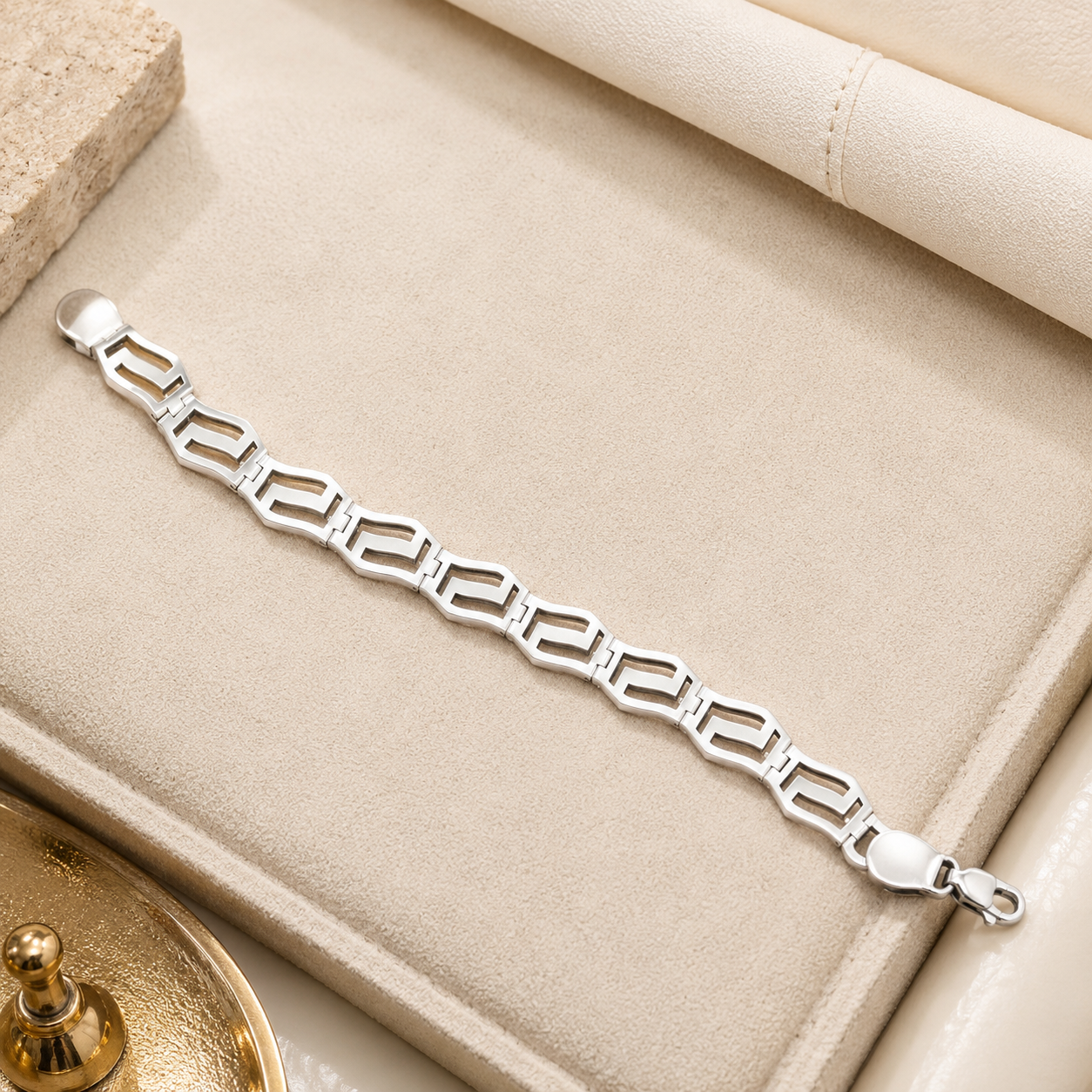 Detailed view showing the lobster claw clasp and fluid chain structure of the geometric silver bracelet.