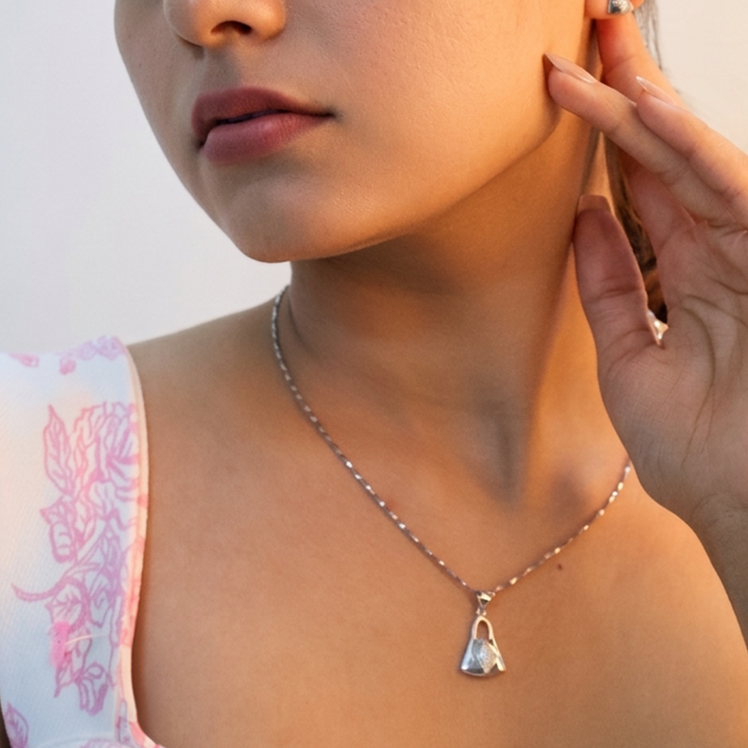 Detailed shot of the push-back handbag stud earrings and matching pendant in sterling silver