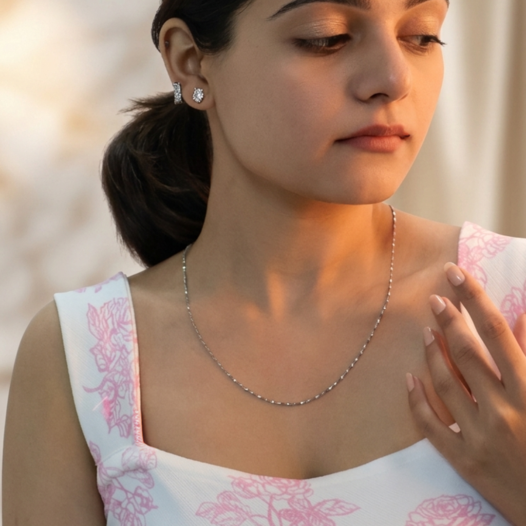 Close up view of a silver Singapore chain draped elegantly around a woman's neck