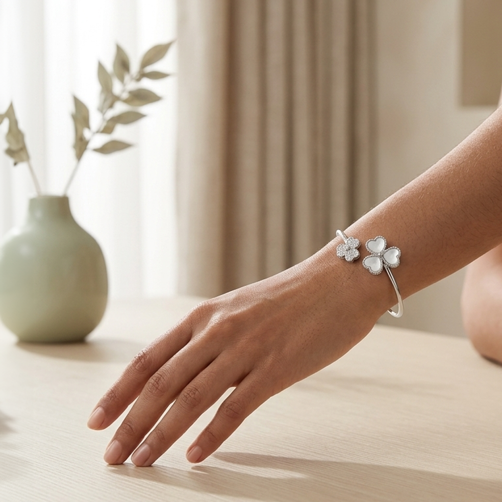 Side view of the Triple Heart Open Kada worn on a woman's arm resting on a table near a pale green vase.