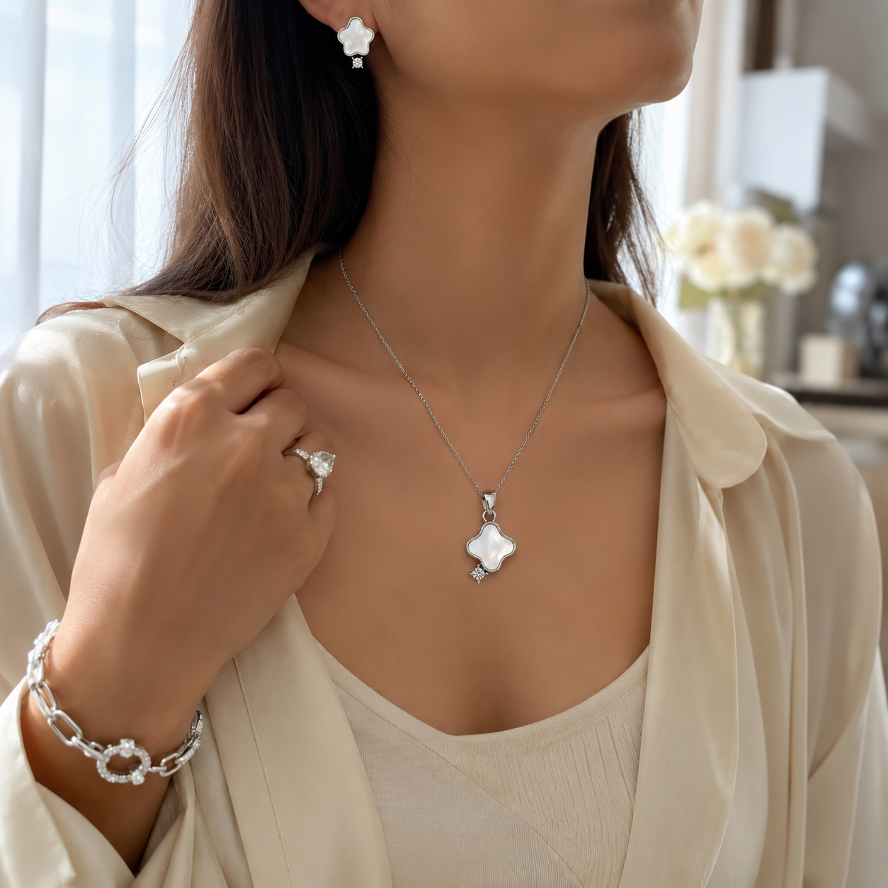 Matching jewelry set showing white shell clover earrings and a pendant on a white background