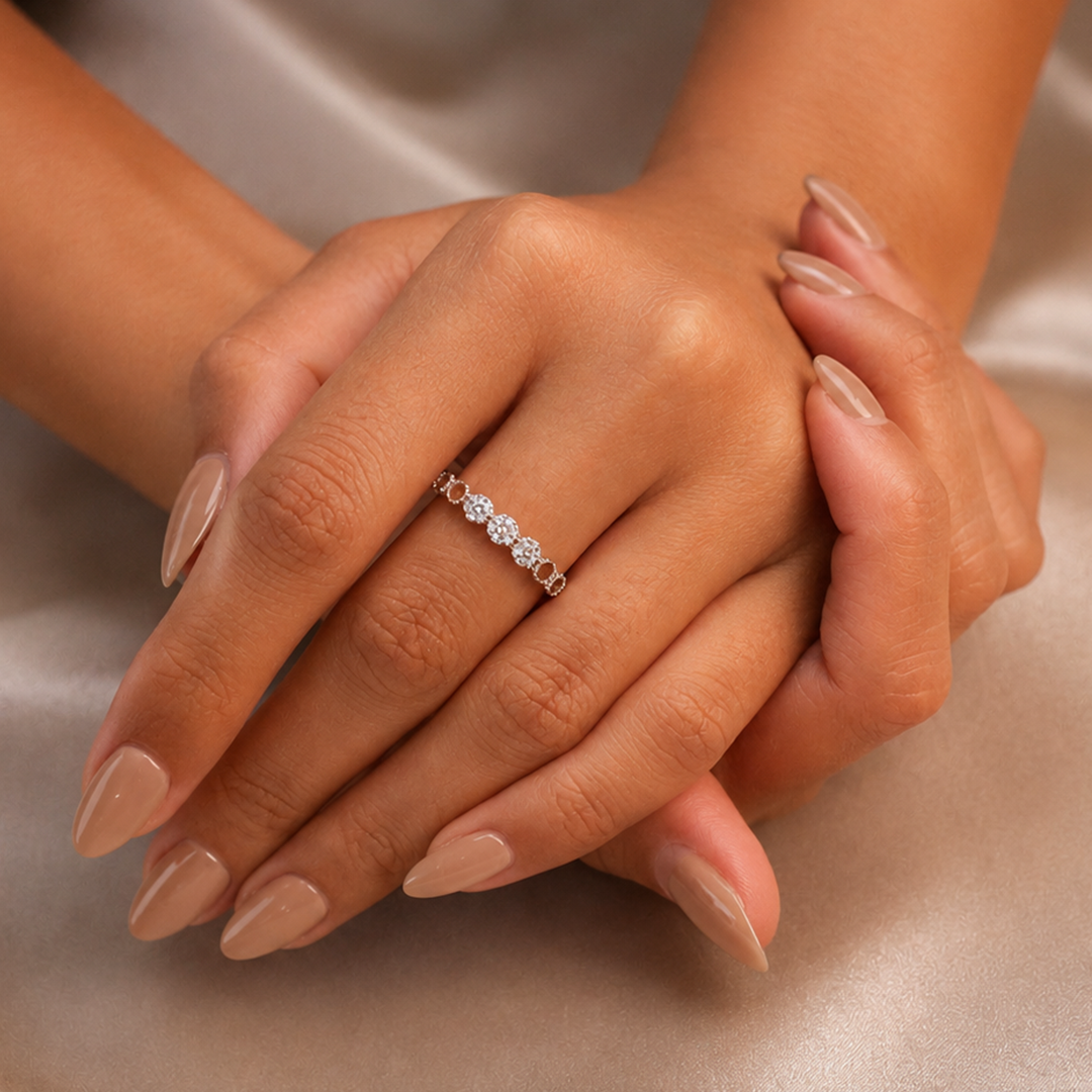Close-up of a woman's hands with beige manicure wearing the delicate Alternating Halo Sterling Silver Ring.