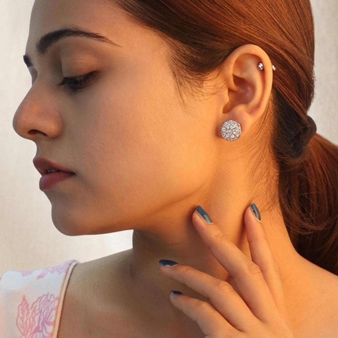 Side profile of a woman adorned with the Brilliant Round Halo Silver Stud Earrings, highlighting its radiant sparkle