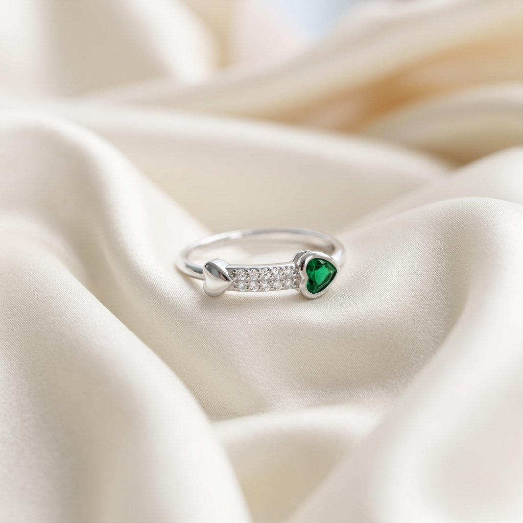 Emerald Heart Pave Sterling Silver Ring resting gracefully on luxurious white silk fabric.