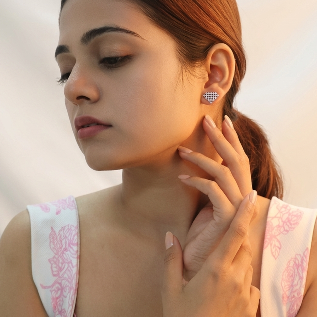 Front-facing portrait of a woman looking down softly while wearing the Geometric Diamond-Shaped Silver Crystal Stud Earrings with a floral dress.