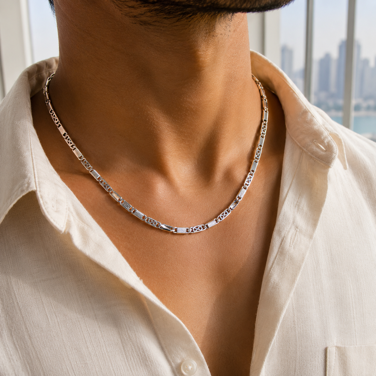 A man wearing the Men's Sterling Silver Alternating Textured Link Chain over a white linen shirt.