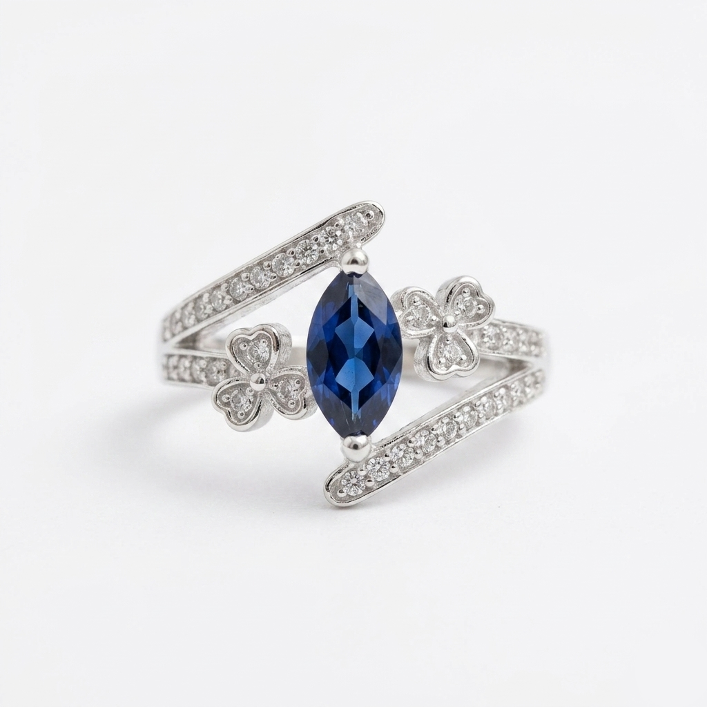 Studio shot of the Neelam Blossom Silver Bypass Ring with a blue marquise stone and diamond-studded flower motifs on a plain white background.