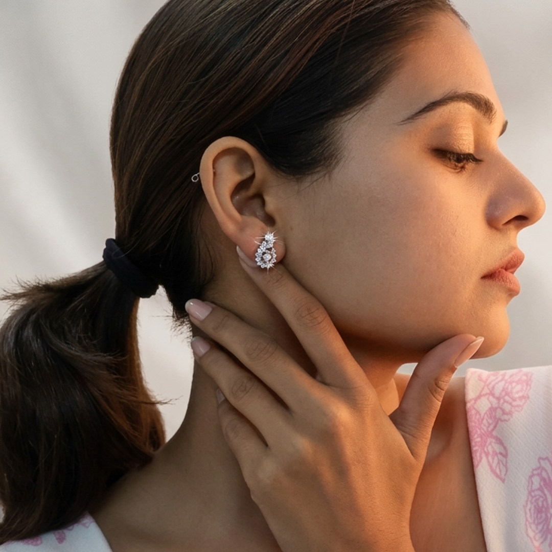 Beautiful woman modeling the Radiant Floral Swirl Silver Stud Earring in soft, warm lighting