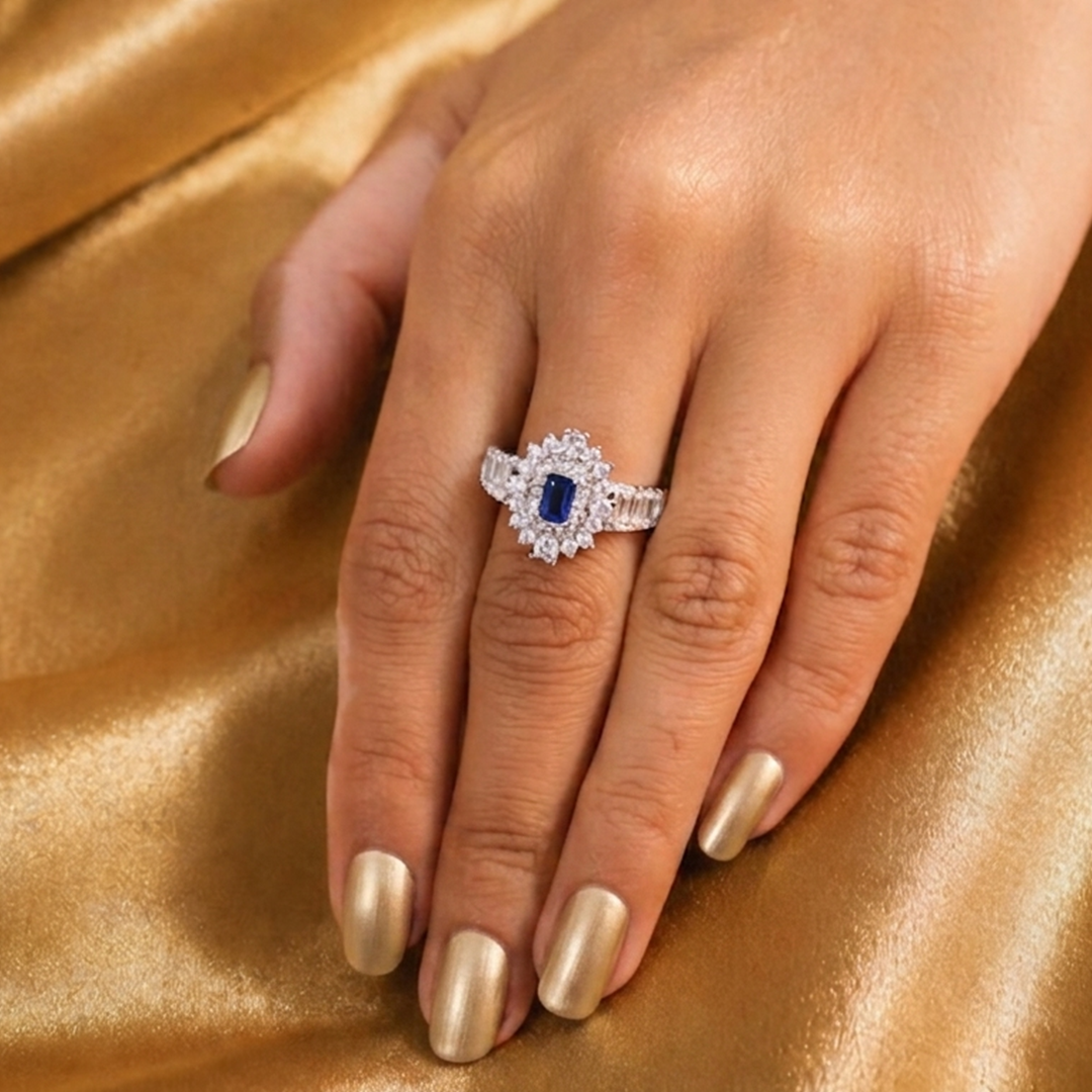 Royal Neelam Halo Statement Ring worn on a finger against a textured golden silk background
