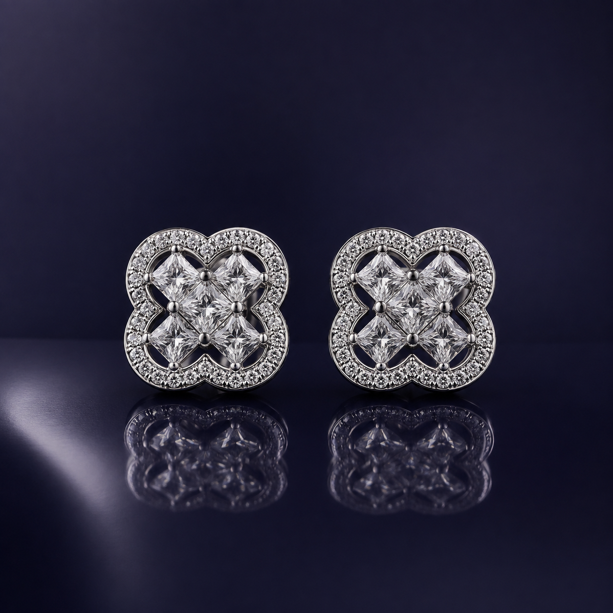 Front display of Silver Clover Stud Earrings (Princess Cut CZ), highlighting the four-stone centre and sparkling clover-shaped border set in a dark reflective background