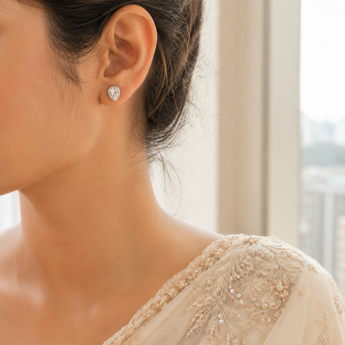 Model wearing Silver Dainty Pear Cut Solitaire CZ Stud Earrings with a minimal pear-shaped solitaire design