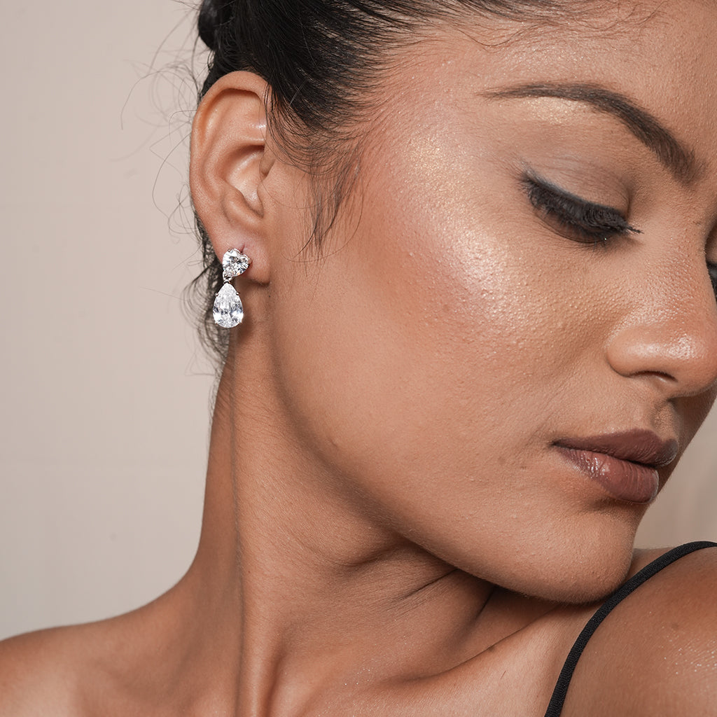 Model wearing Silver Heart & Pear CZ Drop Earrings with a sparkling heart top and dangling pear-shaped CZ stone