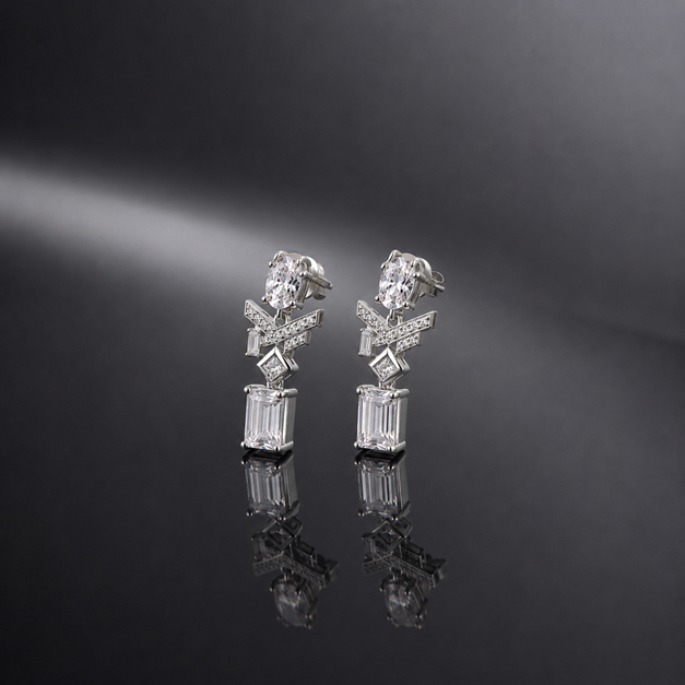 Pair of Silver Oval Baguette CZ Emerald Cut Drop Earrings displayed on a dark reflective surface