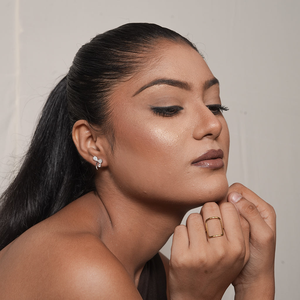 Side profile view of model wearing silver bow stud earring