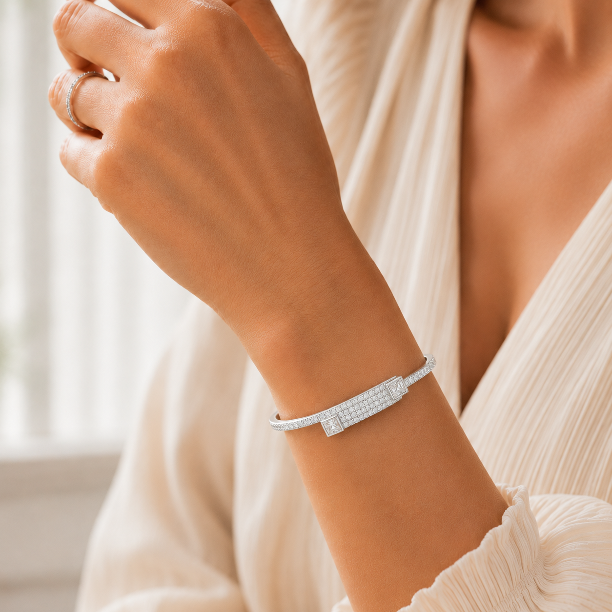 Close-up view of the overlapping pave bands and square terminal stones on the silver bangle.